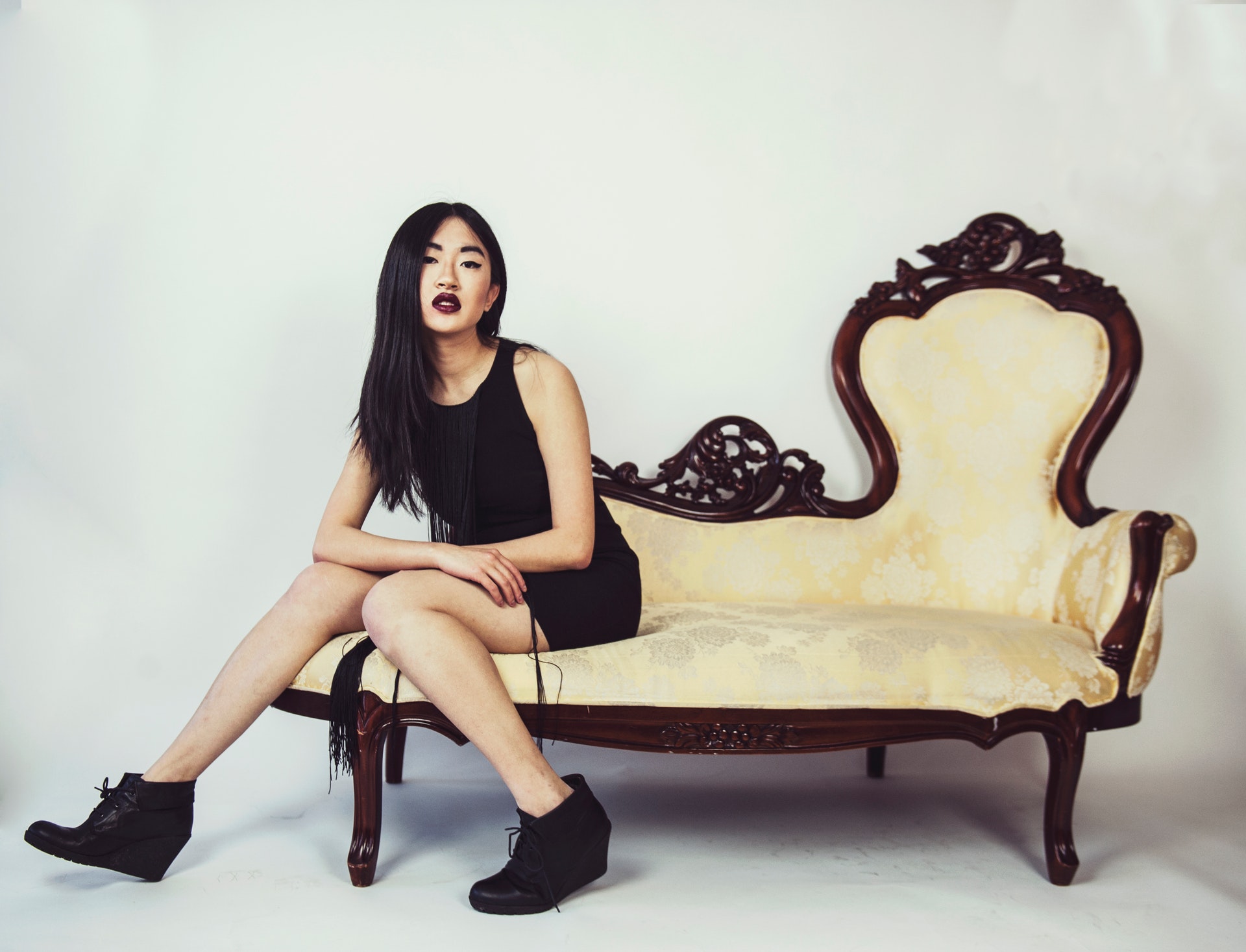 photo-of-woman-wearing-black-dress-while-sitting-on-couch-2495732.jpg